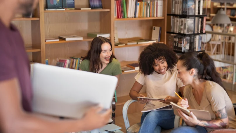 A group of students studying together at a library table.