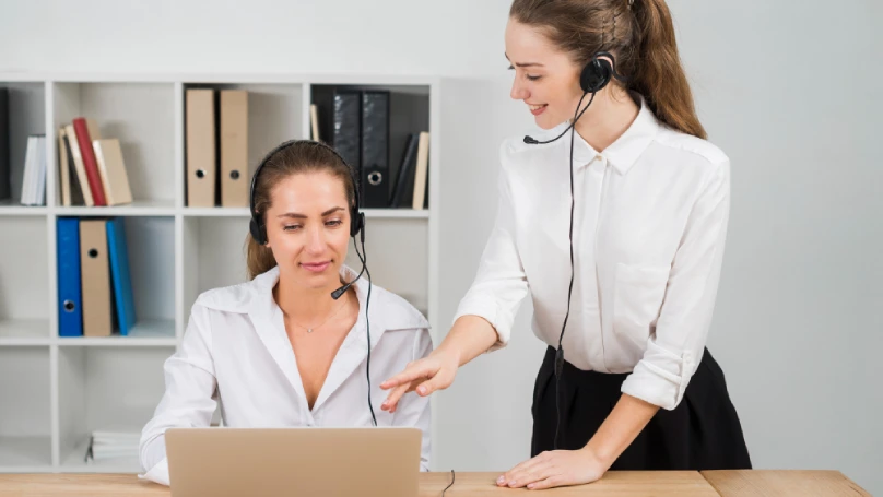 A smiling customer service representative assisting a customer with a friendly demeanor