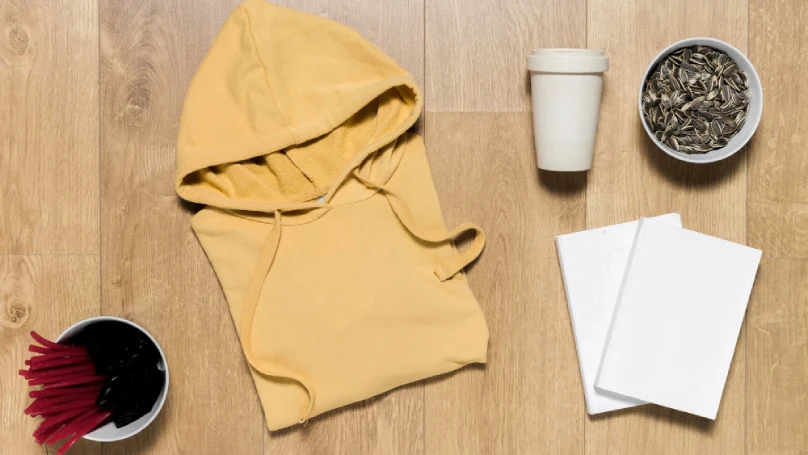 A flat lay of cute merch items like a hoodie, mug